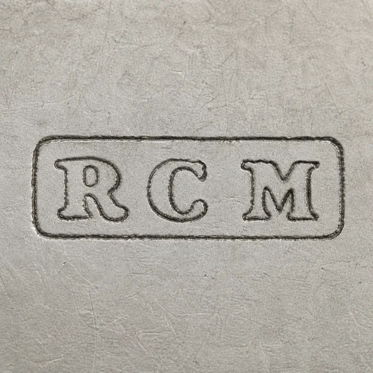 R C M: Corrected R C M arrangement left to right inside one compact worn rectangular cartouche, with unsupported interior dot-like marks removed; oxidized reconstruction.