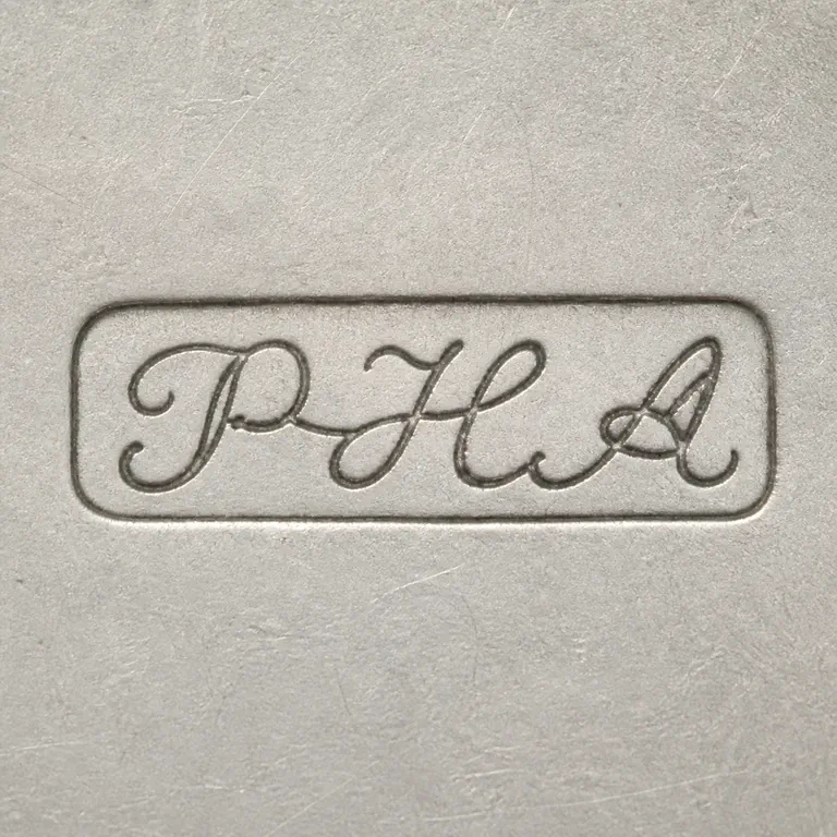 Philip Hanson Abbot: PHA as three connected cursive uppercase letterforms, read left to right P, H, A, inside one long narrow rounded-rectangle cartouche; oxidized reconstruction.