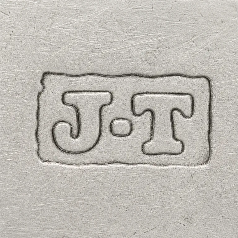 J T: Horizontal rough rectangular mark with J-like and T-like interior forms and a source-positioned central small form; oxidized reconstruction.