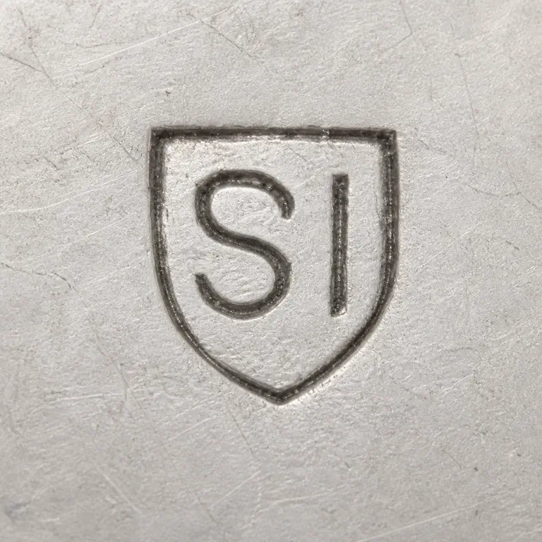 S I: A shield outline with one broad S-like contour and a separate vertical I-like contour is reconstructed pointed lower form; oxidized reconstruction.