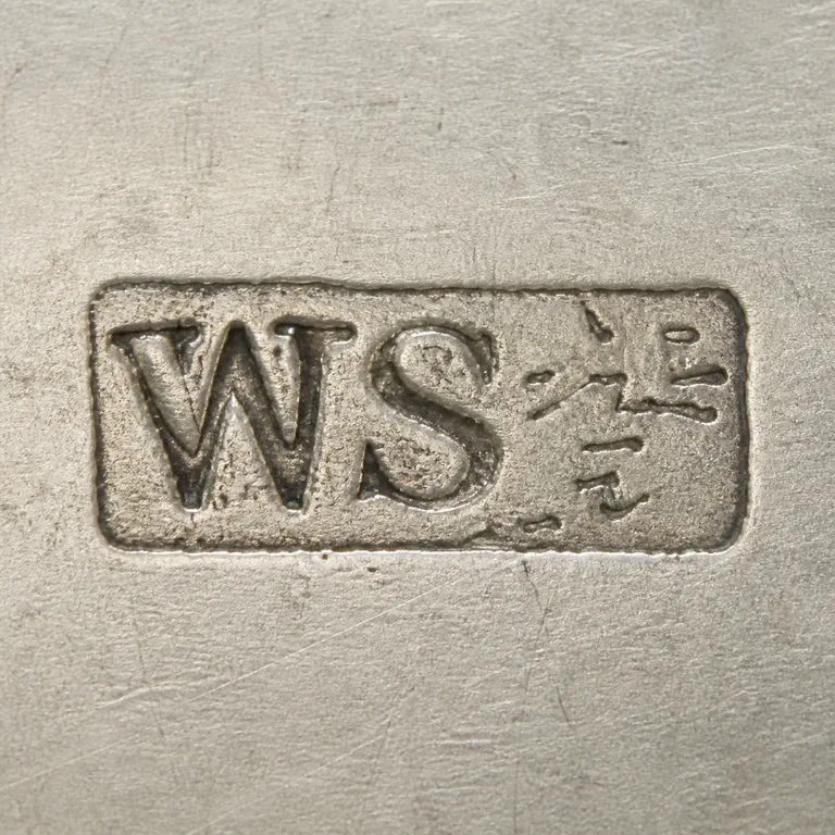 SILVERSMITH: One outer rectangular enclosure contains uppercase WS at left and a deliberately unresolved set of separated worn stroke fragments at rig…; oxidized reconstruction.