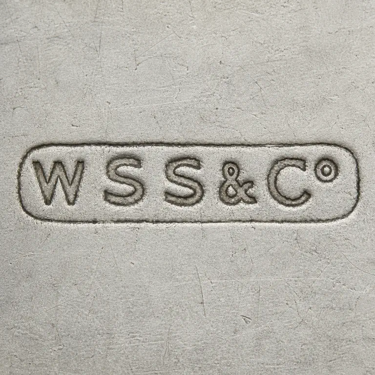 W. S. Savage & Co.: WSS&Co as uppercase W, S, S, one ampersand, uppercase C, and one small raised lowercase o on one line inside one long worn rounded-rectan…; oxidized reconstruction.