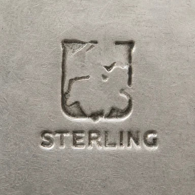 Mary C. Knight: Two-tier mark with a worn incomplete rectangular cartouche containing sparse unresolved strokes above STERLING; oxidized reconstruction.