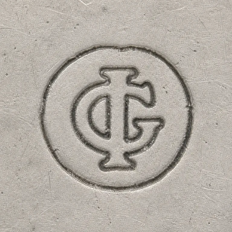 James Gould: Intertwined or closely connected I and G forms inside one compact circular medallion; oxidized reconstruction.