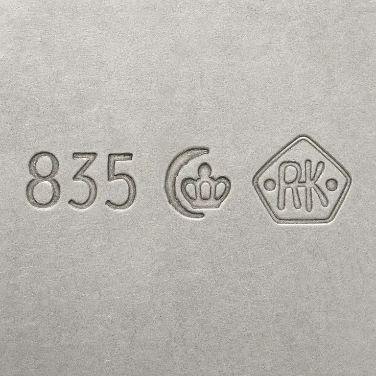 Richard Köberlin: Exact 835, compact crown-like punch, and pointed bordered terminal with linked RK-like strokes and two dots; oxidized reconstruction.