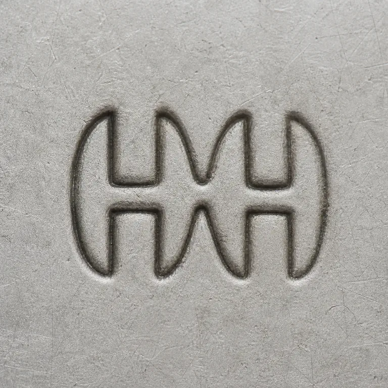 Harrison & Howson?: Two joined uppercase H letters forming one compact double-arched HH monogram without punctuation and without a separate enclosure; oxidized reconstruction.