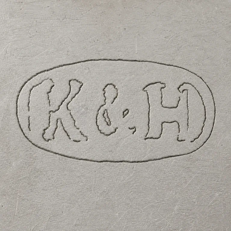 Kuchler & Himmel: Very worn oval punch with K-like left group, ampersand-like central fragment, and H-like right group; oxidized reconstruction.