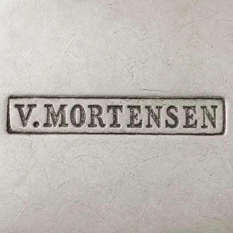VA: V.MORTENSEN in worn serif capitals with one period after V inside one narrow rectangular cartouche; oxidized reconstruction.