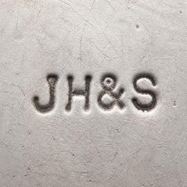 J Harris & Sons: Visible J and H glyphs are followed by an ampersand-like separator and S; the corrected master leaves the J/H gap plain and retains the c…; oxidized reconstruction.