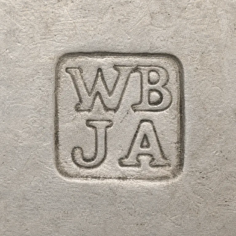 William Briggs & Co: The four visible glyphs W/B over J/A remain in a two-by-two arrangement inside a worn square cartouche; oxidized reconstruction.