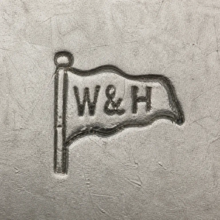 Walker & Hall: W&H as uppercase W, one ampersand, and uppercase H inside one outlined waving flag attached to a single vertical staff with a small round…; oxidized reconstruction.