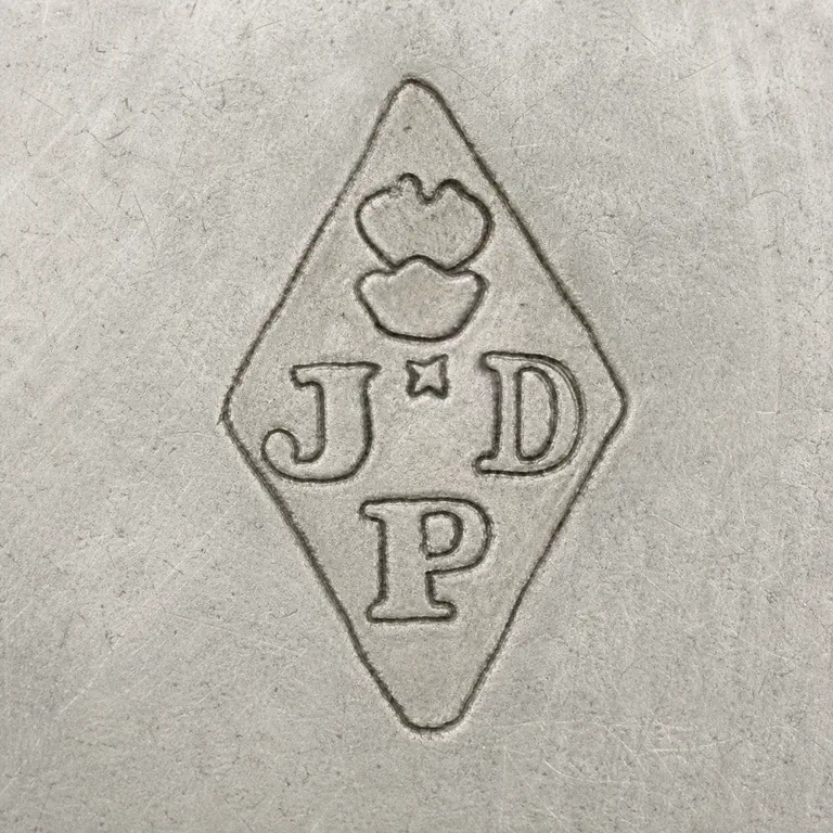 Joseph Antoine: One vertical diamond with J at left, D at right, P below, an upper two-lobed clustered device, and a small central star-like crossing; oxidized reconstruction.