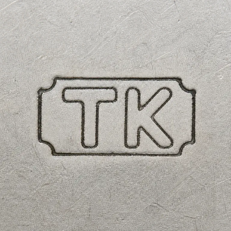 T K: T K arranged left to right inside one compact worn rectangular cartouche; oxidized reconstruction.
