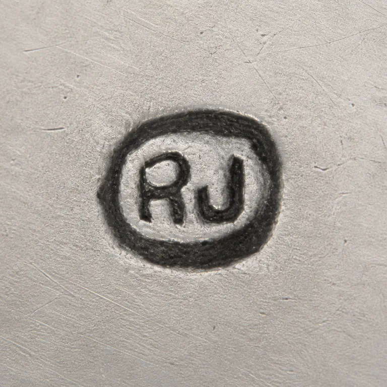 R Jordan: R J arranged left to right inside one compact rounded oval cartouche; oxidized reconstruction.