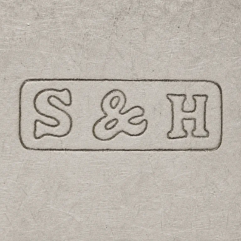 Samsom & Harwood: S&H as uppercase S, one ampersand, and uppercase H on one line inside one long narrow rectangular cartouche; oxidized reconstruction.