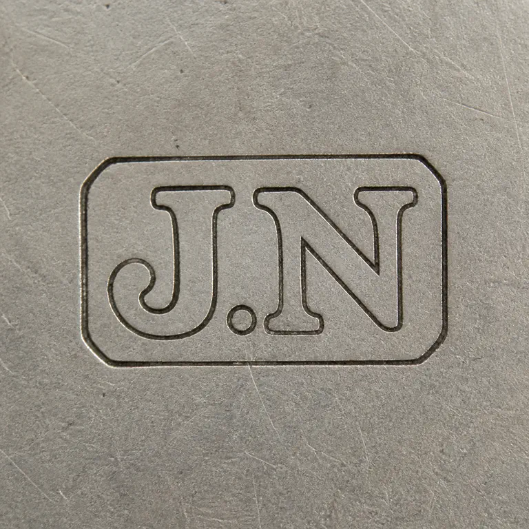 John Nowill: Square contour reconstruction preserves the rounded rectangular frame, supported J/N initials, central separator, and orientation; oxidized reconstruction.