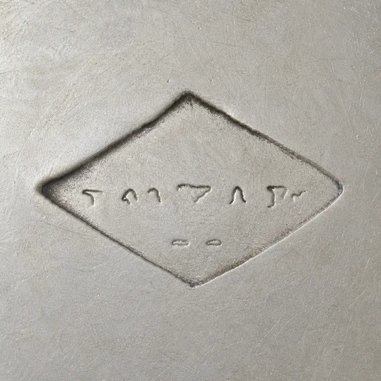 Joseph Antoine: Horizontal diamond border with a sparse disconnected middle row and exactly two short lower marks; oxidized reconstruction.