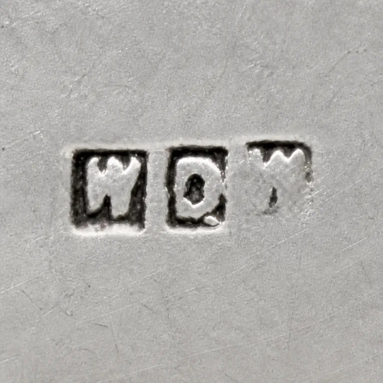 W D W: Three separated square punches with W-like left, D-like center, and incomplete right strokes retained; oxidized reconstruction.