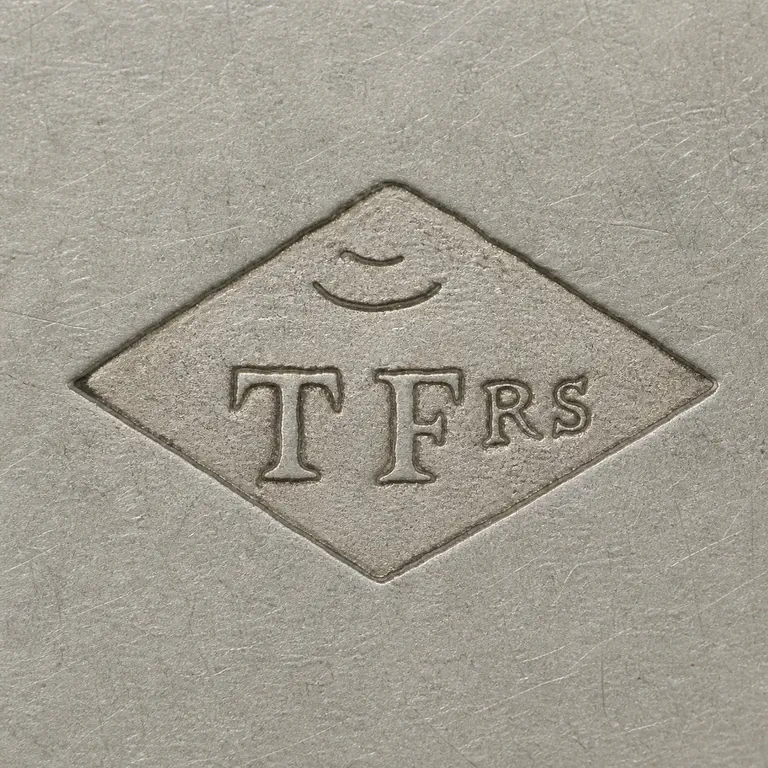 Tallois & Mayence: Horizontal diamond with two shallow unresolved upper arcs uppercase group T FRS, with RS smaller after F; oxidized reconstruction.