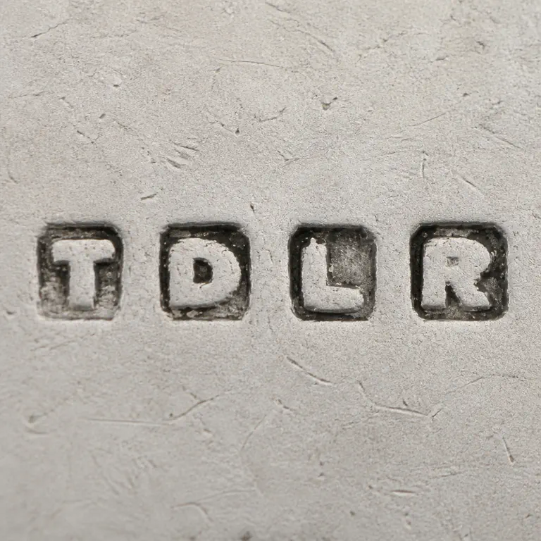 Thomas de la Rue & Co: Clean redraw preserves the separate T, D, L, and R square punches in source order; oxidized reconstruction.