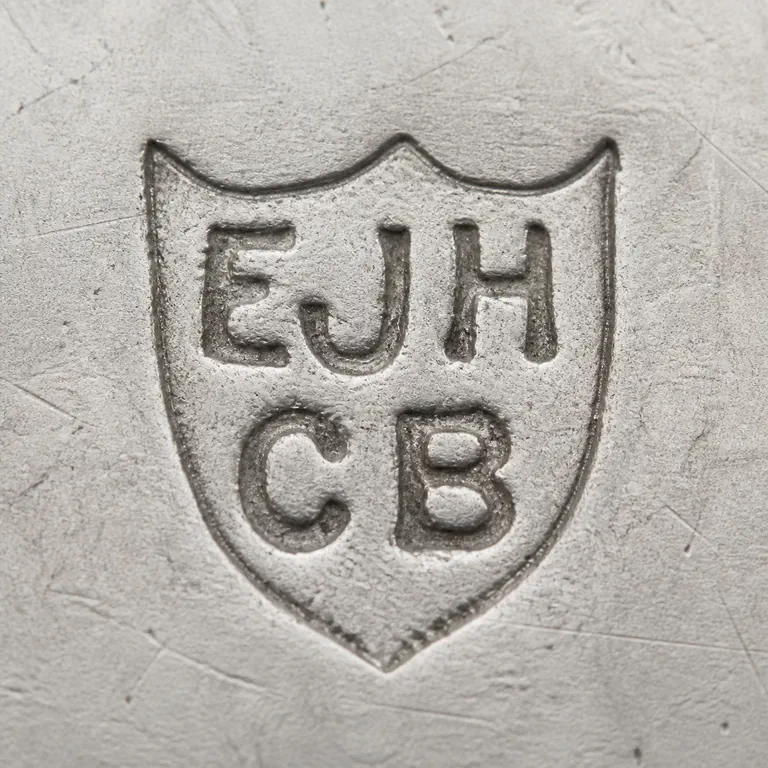 Haseler & Bill (E J Haseler & C Bill): The irregular shield silhouette, EJH upper tier, CB lower tier, source orientation, and pointed base. The and no unsupported outer frame…; oxidized reconstruction.