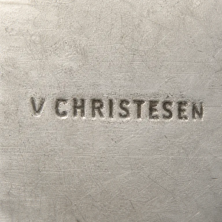 VA: V CHRISTESEN in very condensed uppercase letters with a small space after V and no clearly supported cartouche; oxidized reconstruction.