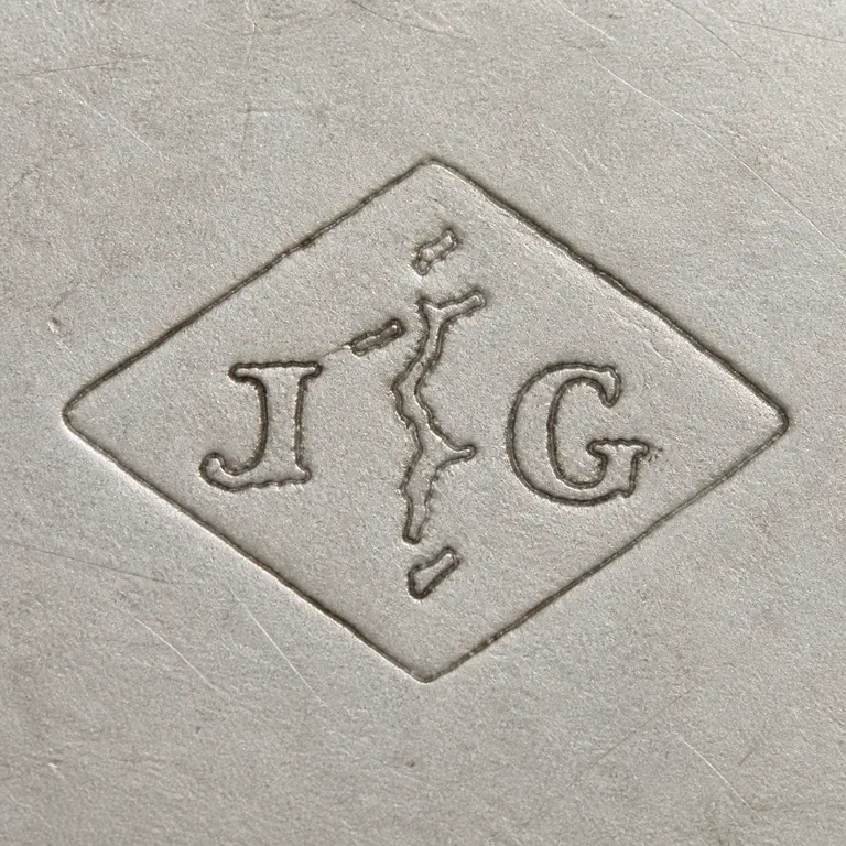 Joseph Antoine: One horizontal diamond with J at left, G at right, a sparse broken central vertical stroke with short branches, and small detached upper…; oxidized reconstruction.