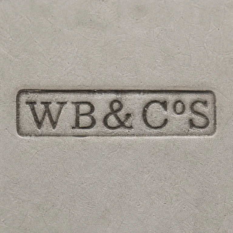 William Briggs & Co.: WB&CoS as uppercase W and B, ampersand, uppercase C, small raised lowercase o, and uppercase S on one line inside one long narrow rectang…; oxidized reconstruction.