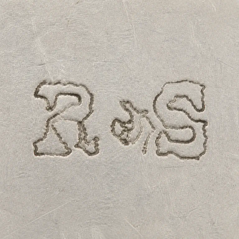 R S: Two worn R/S-like forms and their source spacing are retained without added punctuation; oxidized reconstruction.