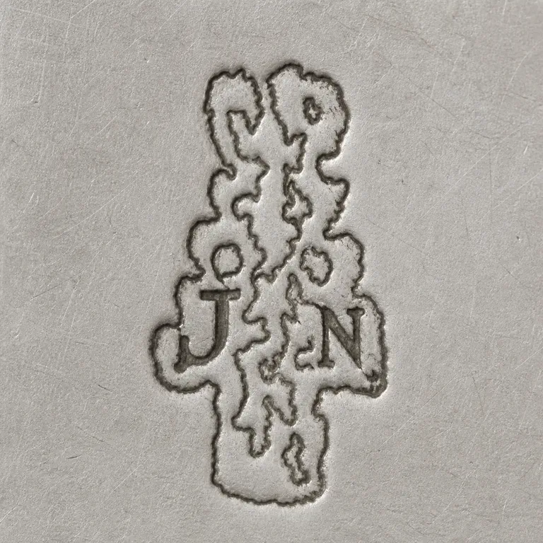 Joseph Antoine: Tiny tall irregular punch with J lower left, N lower right, and one connected asymmetric unresolved vertical contour; oxidized reconstruction.