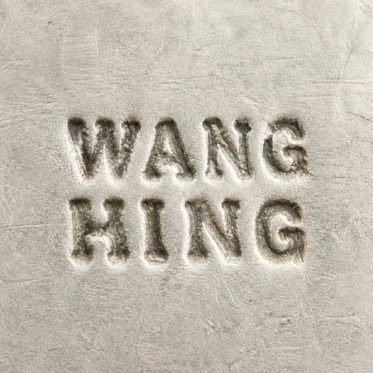 SILVERSMITH: The two-line uppercase WANG over HING wordmark original reading order and no invented enclosure; oxidized reconstruction.