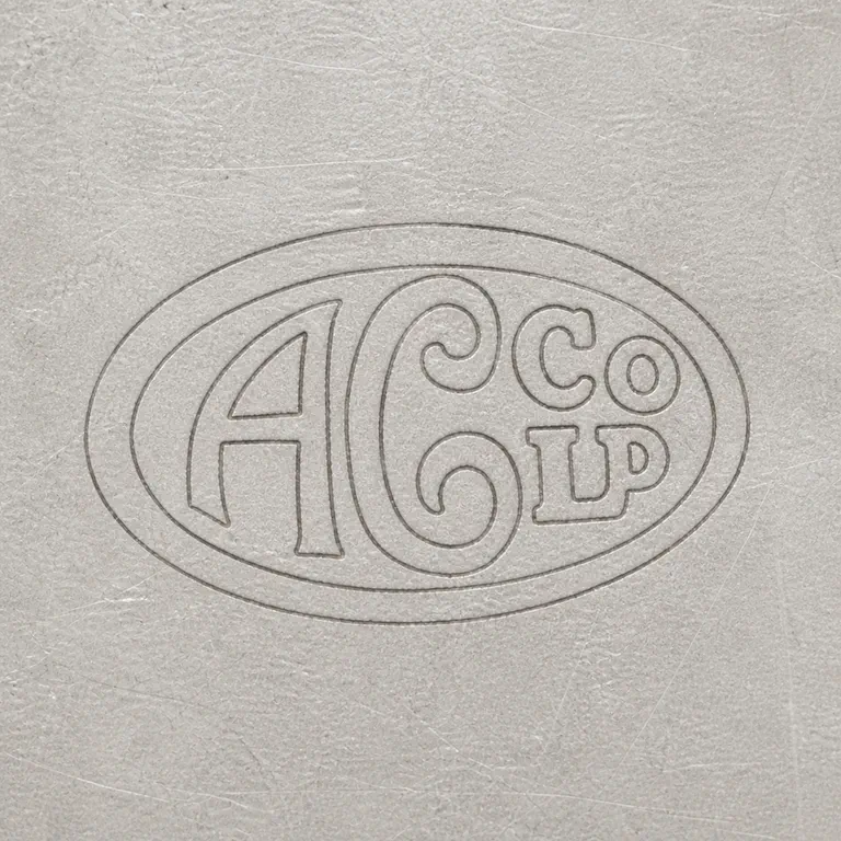The Alexander Clark Manufacturing Co: The oval border, inner oval, large intertwined A/C forms, upper-right Co, and lower-right Ld arrangement as monochrome contours; oxidized reconstruction.