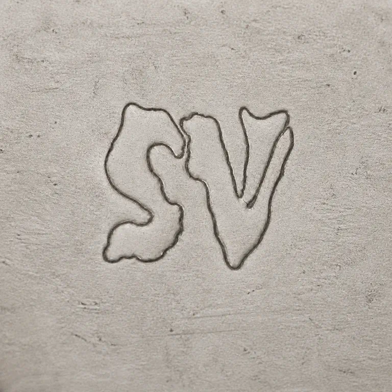 S V: Two compact worn ornamental S/V-like vertical forms in the source orientation without added enclosure or lettering; oxidized reconstruction.
