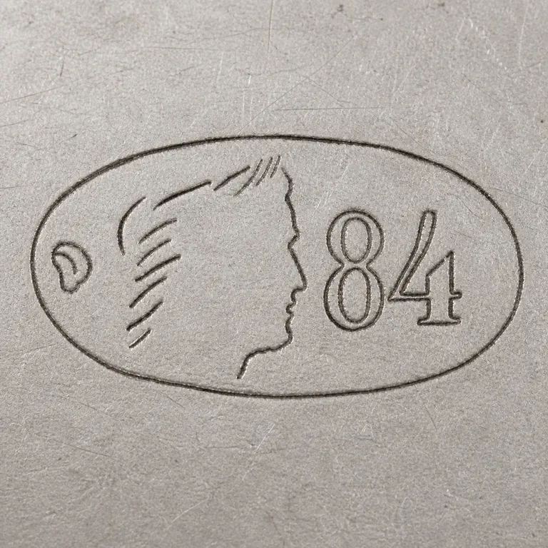 St. Petersburg: One horizontal oval with a tiny irregular loop-like code at left, sparse right-facing profile contours in the center, and 84 at right; oxidized reconstruction.
