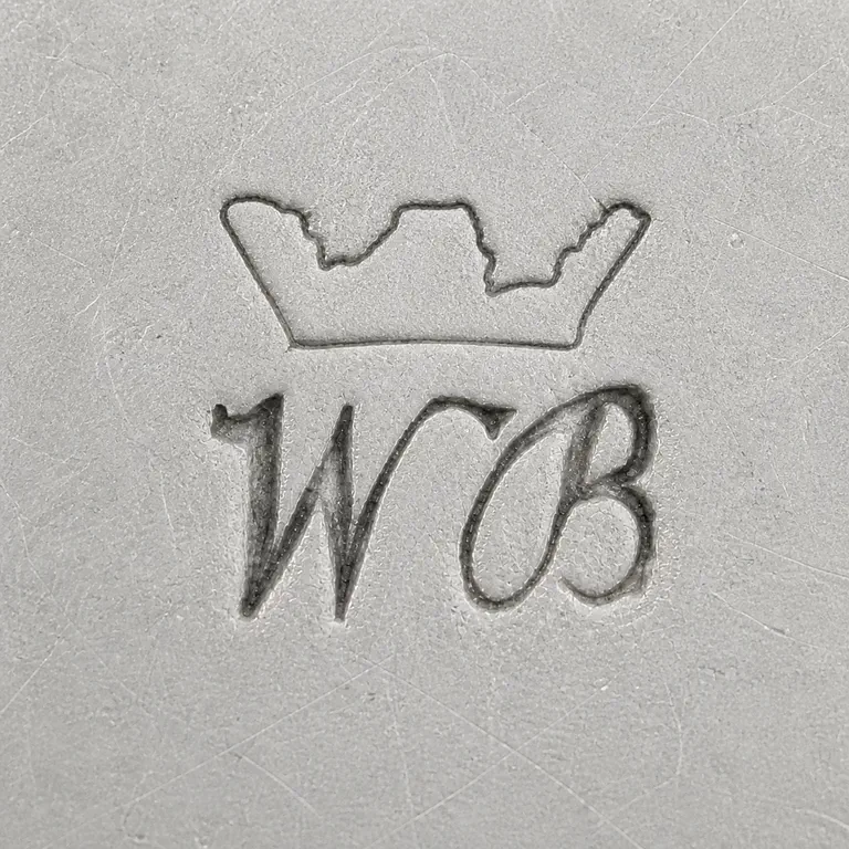 W B: Compact crown-like upper silhouette over W/B-like lower forms, rendered as unfilled gray contours; oxidized reconstruction.