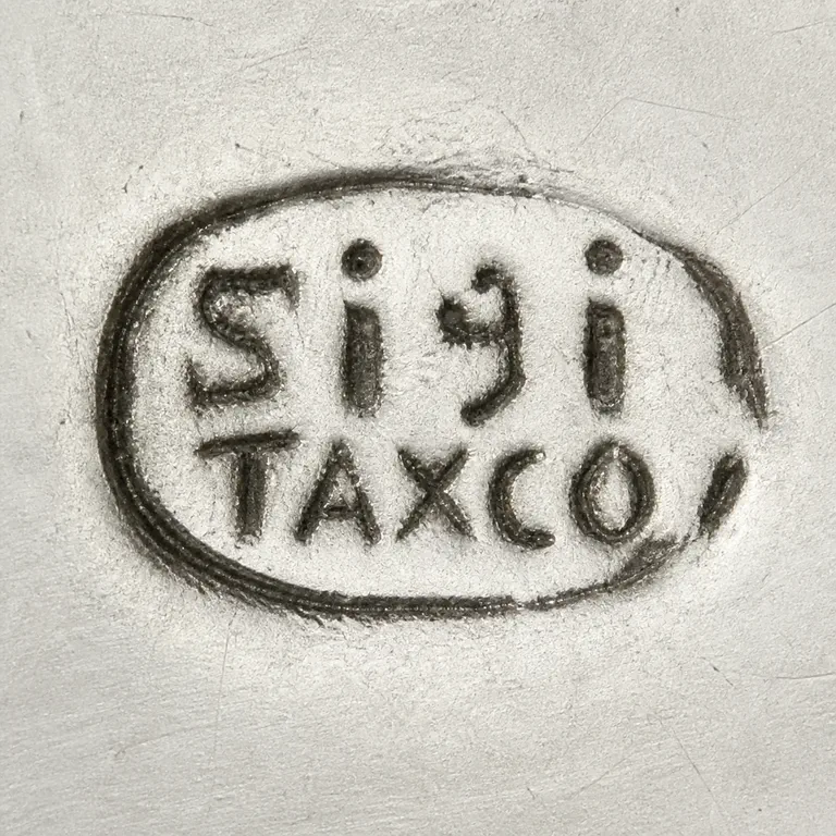 Sigi Pineda: One worn oval contains upper Sigi and lower TAXCO, X retained as crossed diagonals; oxidized reconstruction.