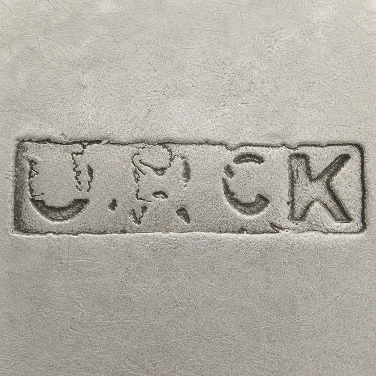 James McKiernan: Long distressed rectangular plaque with partial J/M/C/K-like forms and large unreadable gaps; oxidized reconstruction.