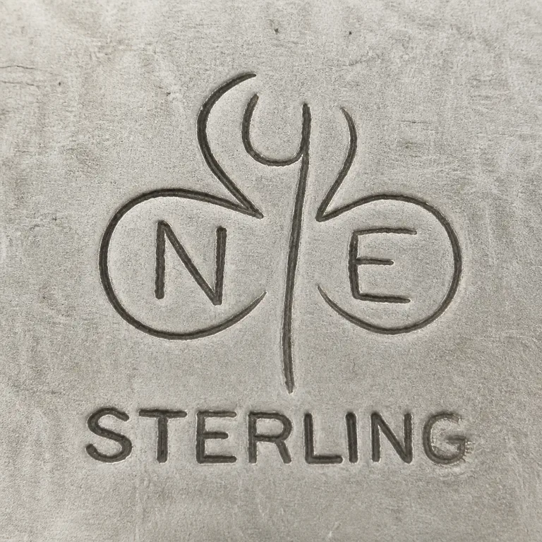 Stuart Nye: A plant-like central device with Y-shaped stem and three rounded lobes containing Y above, N left, and E right, with STERLING below; oxidized reconstruction.