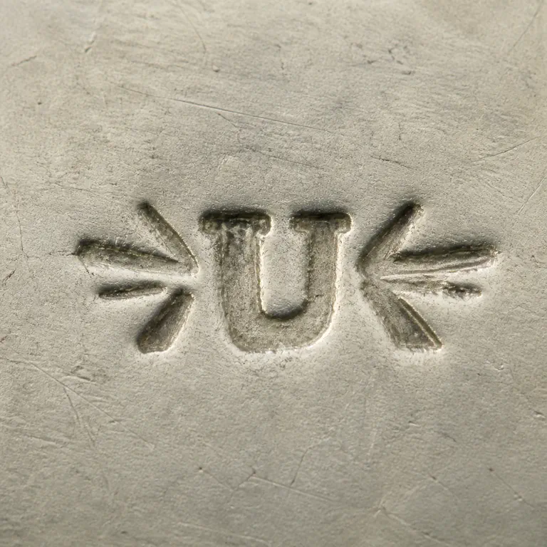 Uncas Mfg. Co.: A broad U-like shape is centered between three tapered strokes on each side; oxidized reconstruction.