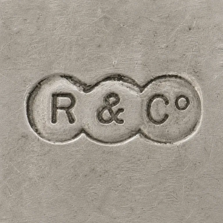 Robinson & Co: Clean redraw preserves the R, ampersand, and Co sequence in three overlapping circular punches; oxidized reconstruction.