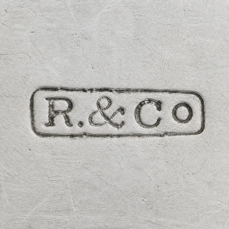 Revell & Co: The R-and-ampersand-and-Co group and its dark rectangular cartouche are reconstructed left-to-right The and no maker label or contextual…; oxidized reconstruction.