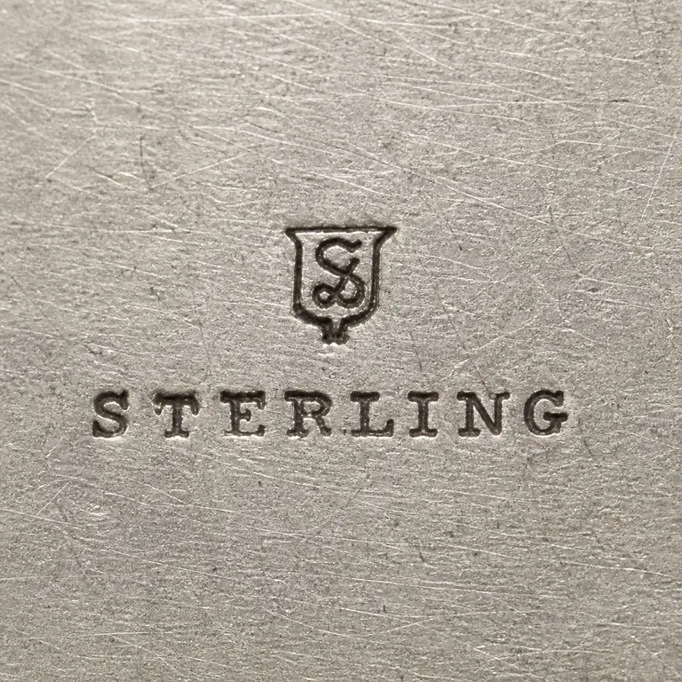 Simons Brothers: S, shield, sterling; oxidized reconstruction.