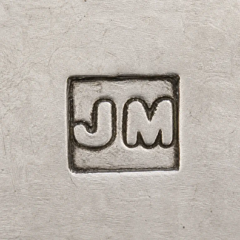 J M: J M arranged left to right inside one compact horizontal rectangular cartouche; oxidized reconstruction.