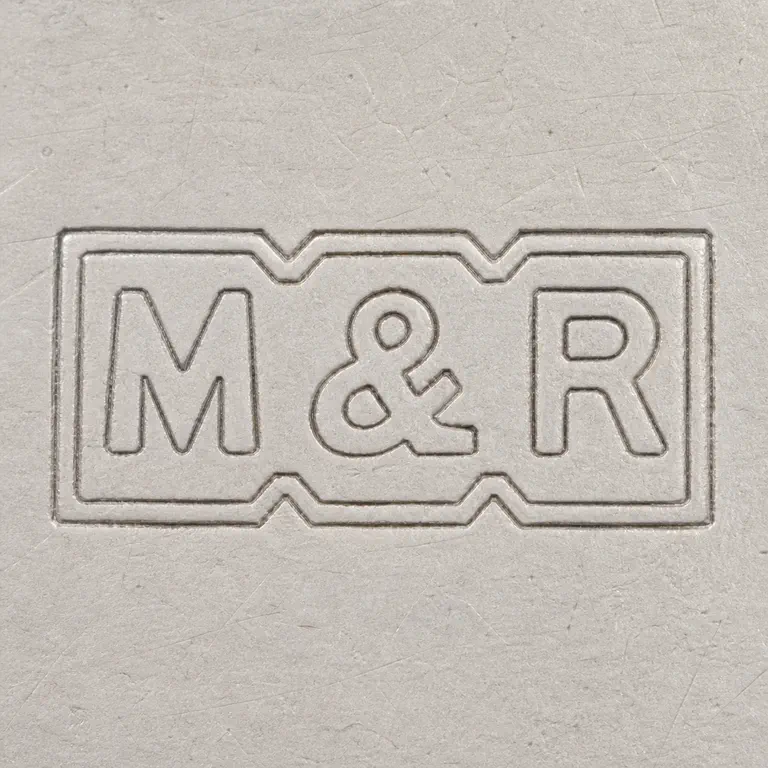 M & R: Horizontal rectangular border with M-like form, ampersand-like separator, and R-like form; notches and spacing; oxidized reconstruction.