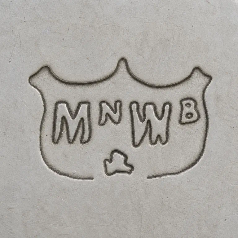 Mappin & Webb Ltd: M/W-like central forms small lower fragment are retained within the supported crest-like boundary; oxidized reconstruction.