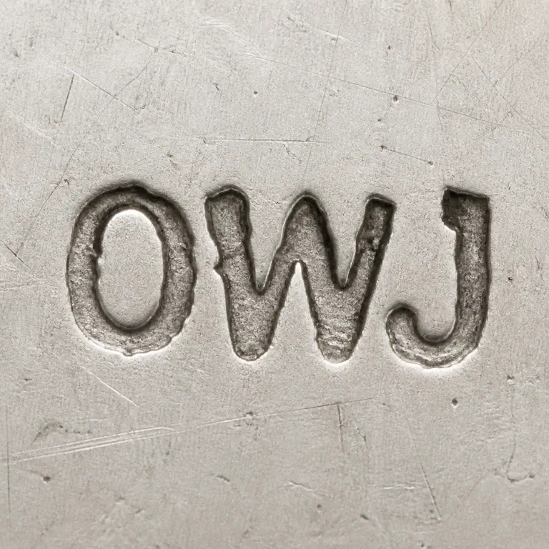 O.A.: Reconstruction preserves the uppercase OWJ wordmark with no enclosing border; oxidized reconstruction.